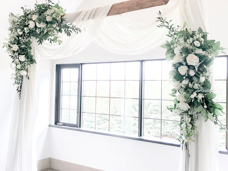 White drape arch with florals