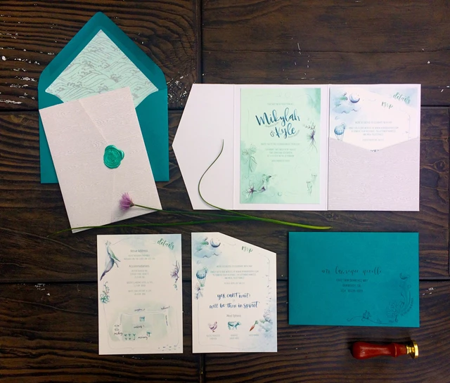 Boho Watercolour Invitation Suite with succulent and mermaid details. Pieces include invitation with two tiered detail cards in pocket enclosure, outer envelopes with foil embellished liners, and seahorse wax seal.